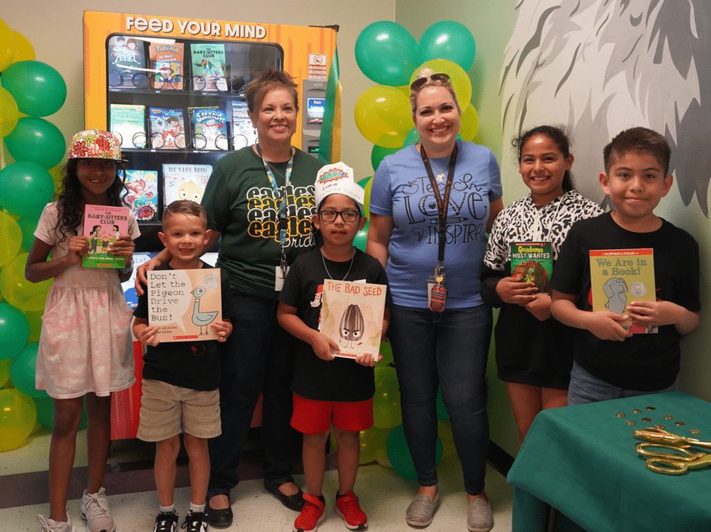 Group of students showing off their new books.
