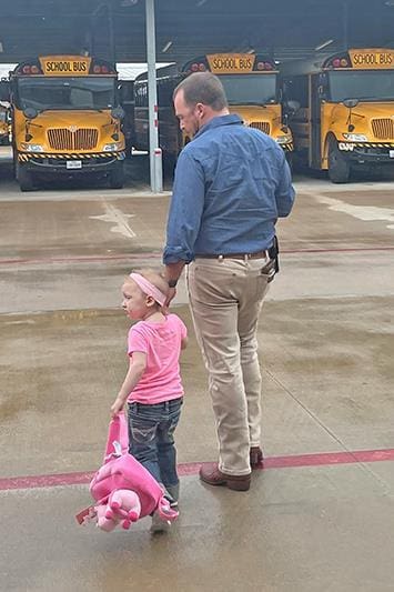 Olivia walking towards the buses.