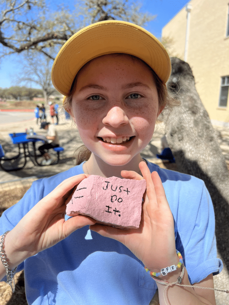 Student showing off a rock with the words "Just Do It" written on it.