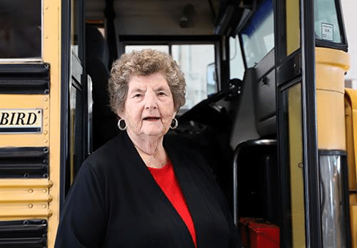 Peggy Worrel posing with the bus.